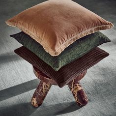 four pillows stacked on top of each other in front of a gray flooring area