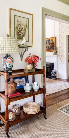 a living room filled with furniture and flowers on top of a wooden shelf in front of a fire place