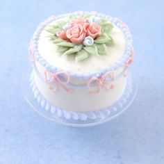 there is a small white cake with pink flowers on it