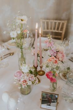 the table is set with flowers and candles