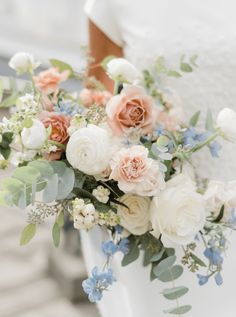 a bridal holding a bouquet of flowers and greenery