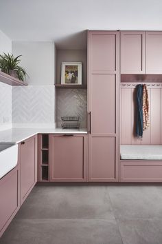 a kitchen with pink cabinets and white counter tops