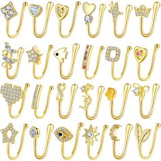 many different types of gold ear clips with diamonds and hearts on each side, all in various shapes and sizes