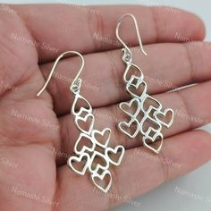 Elevate your style with these exquisite handcrafted silver dangle earrings. Each earring features a unique geometric heart design meticulously crafted from high-quality 925 sterling silver. The interlocking hearts create an elegant cascading effect, perfect for adding a touch of sophistication to any outfit. The lightweight construction ensures comfortable wear, while the secure hook backing provides ease of use. Whether for a special occasion or everyday elegance, these earrings are a must-have Silver Dangle Heart Earrings, Pierced Dangle Heart Earrings For Mother's Day, Valentine's Day Sterling Silver Drop Earrings, Sterling Silver Dangle Heart Earrings, Teardrop Heart Earrings In Sterling Silver, Silver Heart Drop Earrings For Mother's Day, Nickel-free Sterling Silver Dangle Heart Earrings, Silver Minimalist Heart Dangle Earrings, Sterling Silver Heart Drop Earrings For Gift