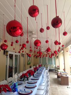 a long table with red ornaments hanging from the ceiling