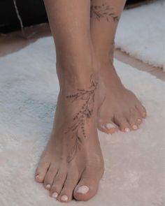 a woman's bare feet with tattoos on them