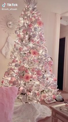 a white christmas tree decorated with pink and silver ornaments