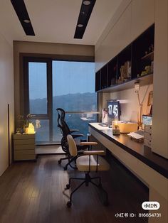 an office with a desk, chair and large window overlooking the city outside at night