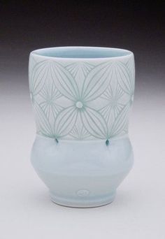 a white and blue vase sitting on top of a table