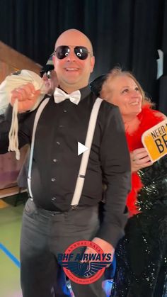 a man in a tuxedo and bow tie is posing for a photo with a woman