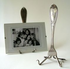 a silver spoon sitting on top of a table next to a picture frame