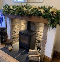 the fireplace is decorated with greenery and other things to put on it's mantle