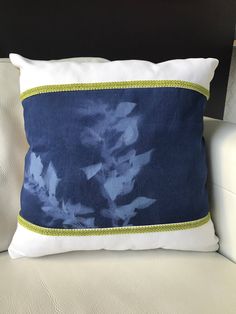 a blue and white pillow sitting on top of a couch