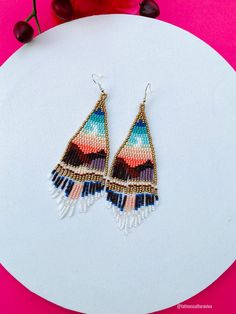 These beautiful beaded earrings are so colorful and perfect for all-day wear. They are definitely the perfect accessory to style up your look and add personality to your outfit. These lovely handmade earrings are made with sterling silver hooks and colorful beads. Each pair of earrings that we sell is authentic and one-of-a-kind! Finds more styles at https://www.etsy.com/shop/LatinxsCulturaViva?ref=simple-shop-header-name&listing_id=990207426&section_id=26730499 Thank you so much for visiting. I Jewelry Mexican, Huichol Earrings, Aztec Earrings, Beautiful Beaded Earring, Mexican Earrings, Beaded Earring, Boho Style Earrings, Handmade Earrings Beaded, Beaded Earrings Patterns