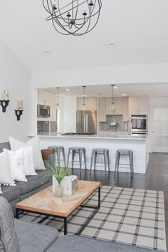 a living room filled with furniture next to a kitchen