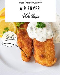 an air fryer meal on a white plate with lemon wedges and sour cream