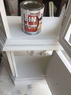 a can of paint sitting on top of a white shelf