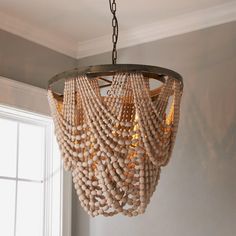 a wooden beaded chandelier hanging from a ceiling