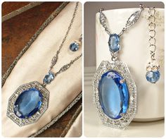 Offering an absolutely stunning vintage 1920s to 1930s era Art Deco sapphire blue bezel set faceted glass crystal and silver rhodium plated filigree pendant necklace.  This is the perfect "Something Old" and "Something Blue" for the bride!   The 1 5/8 inch (41 cm) by 1 1/4 inches at 1 5/16 inches (3.3 cm) ornate embossed filigree pendant features a central oval cut bezel set faceted glass crystal in the most beautiful shade of sapphire blue.  It hangs from a smaller open back faceted glass crystal also in blue.  This in turn is suspended from rhodium plated filigree links on either side.  The rest of the necklace is a platinum tone replacement chain with that fastens with a ring clasp.  It has an extender chain for versatility and can be worn from about and measures 21 3/8 to 23 7/8 inches Heirloom Blue Necklaces For Weddings, Art Deco Sapphire Jewelry For Wedding, Art Deco Sapphire Wedding Jewelry, Vintage Sapphire Jewelry For Formal Occasions, Antique Sapphire Jewelry For Wedding, Art Deco Sapphire Jewelry With 17 Jewels, Sapphire Art Deco Jewelry With 17 Jewels, Art Deco Crystal Jewelry For Vintage Events, Art Deco Crystal Jewelry For Vintage