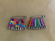 two pairs of multicolored beaded earrings on top of a white tablecloth