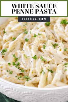 white sauce penne pasta in a bowl with parsley on top