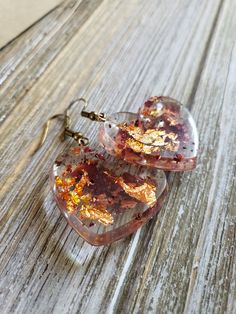 Beautiful natural rose petals in heart resin earrings. Hues of amber red paired with fiery copper flakes make these natural earrings boldly colorful. Bronze metal earrings with handmade resin heart pendants with real dried rose petals ♥ Be sure to check out the ORANGE EARRINGS section at EarringsbyLCreations for all beautiful orange colored earrings available! https://www.etsy.com/shop/EarringsByLCreations?section_id=28420987 Made with quality materials and always nickel and lead free metals. Na Handmade Heart-shaped Flower Earrings For Gift, Resin Heart Earrings For Gifts, Gold Heart-shaped Flower Earrings, Valentine's Day Heart-shaped Flower Earrings For Pierced Ears, Handmade Heart-shaped Resin Earrings, Heart-shaped Resin Jewelry For Valentine's Day, Heart Shaped Resin Jewelry For Valentine's Day, Heart-shaped Gold Flower Earrings For Valentine's Day, Gold Heart-shaped Flower Earrings For Valentine's Day