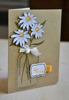 a card with some daisies in a mason jar