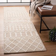 a white rug on the floor in front of a window with a chair and plant