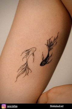 two goldfish tattoo designs on the thighs, one black and one white fish with long tails