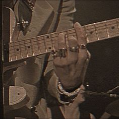 a man is playing an electric guitar while wearing a suit and tie