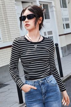 This long-sleeved t-shirt features a classic striped print, perfect for any girl's wardrobe. Made of comfortable, soft fabric, this shirt is both stylish and cozy. The black and white stripes give it a timeless look, while the long sleeves make it suitable for cooler weather. This versatile piece can be worn casually with jeans. #girls #tshirt Girls Tshirt, Crop Top Casual, Crop Top Tees, Girls Stripes, Girls Wardrobe, Cooler Weather, Stripe Print, 16 9