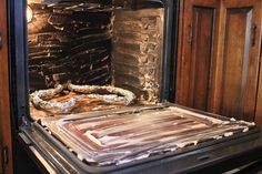 an open oven with some food cooking in it's door and wood cabinets behind it