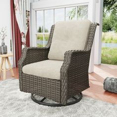 a wicker chair sitting on top of a rug in front of a sliding glass door