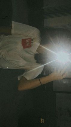 a person holding a cell phone up to their face with the light shining on them