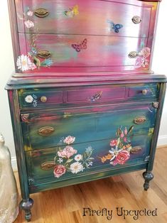 an old dresser has been painted with flowers and butterflies on the top, along with other things