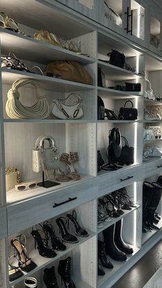 there are many shoes and purses on the shelves