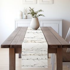 a wooden table topped with a white vase filled with flowers