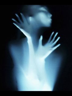 a blurry image of a person's hands reaching out to the light in the dark