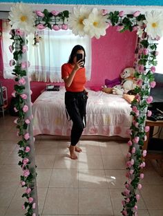 a woman taking a selfie in front of a mirror with flowers on the frame