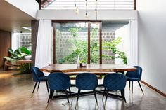 a dining room table surrounded by blue chairs