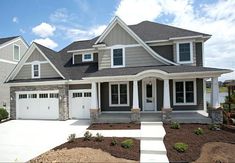 a large house with two garages in the front and one on the other side