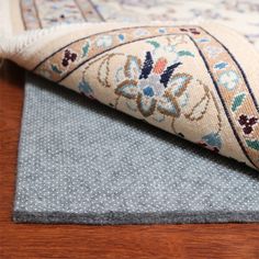 a close up of a rug on the floor with a wooden floor in the background