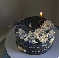 a blue and white cake with a lit candle on top