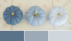 three blue pumpkins sitting on top of a table next to each other with different colors