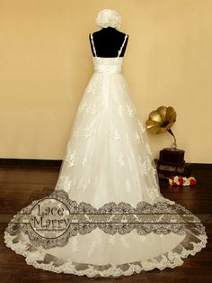 a white wedding dress on display in front of a brown wall and wooden flooring