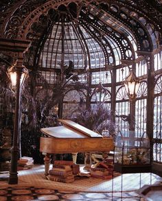 a grand piano sitting in the middle of a room filled with glass walls and windows