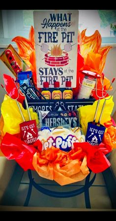 a basket filled with candy and snacks sitting on top of a table next to a sign