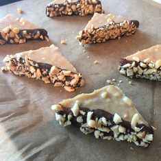 several pieces of chocolate and nuts on a piece of wax paper