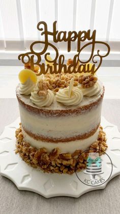 a birthday cake with white frosting and walnuts on the top that says happy birthday