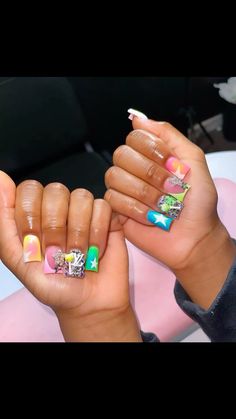 two hands with colorful nail designs on them